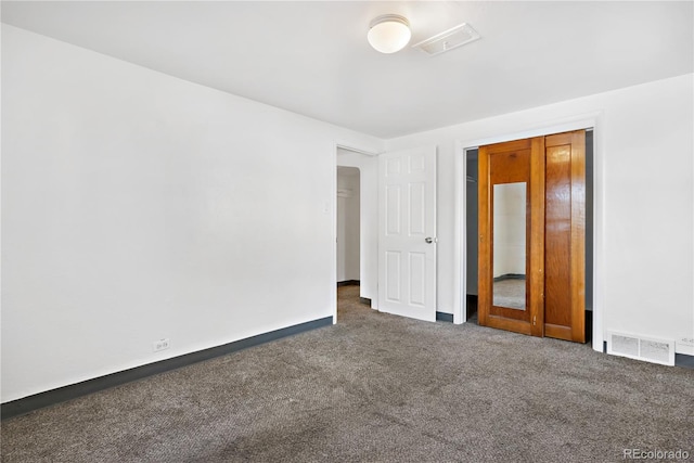 unfurnished room featuring dark carpet