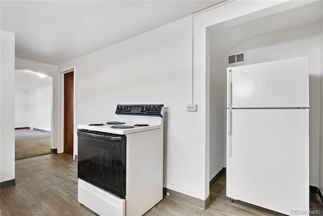 kitchen with white appliances and hardwood / wood-style flooring