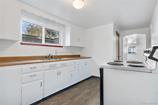 kitchen with a wealth of natural light, white cabinets, dark hardwood / wood-style floors, and white electric range