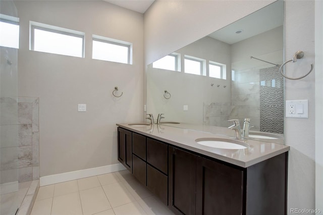 bathroom featuring vanity, tile patterned floors, a tile shower, and plenty of natural light