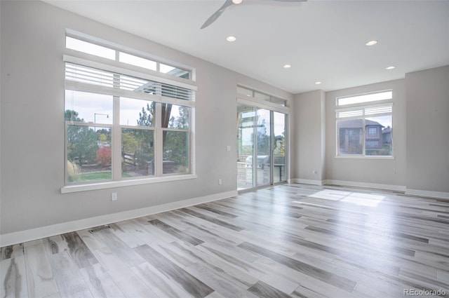 unfurnished room with ceiling fan, light hardwood / wood-style flooring, and plenty of natural light