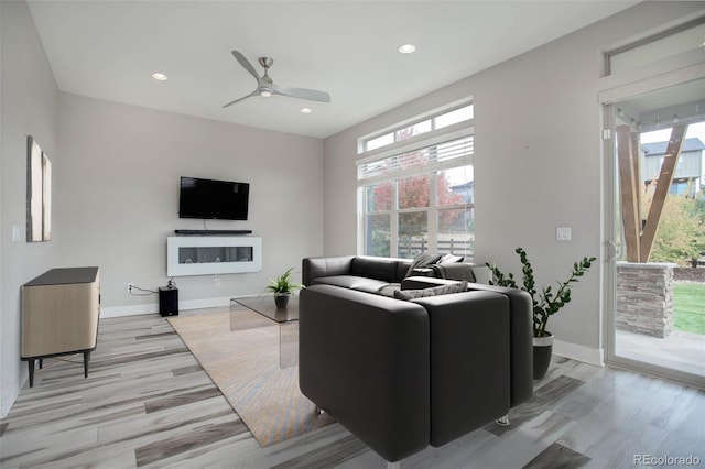 living room featuring ceiling fan and light hardwood / wood-style flooring