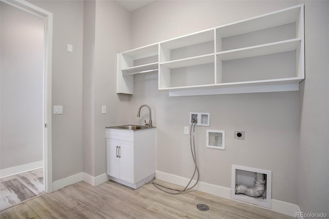 clothes washing area with light hardwood / wood-style floors, hookup for an electric dryer, sink, and hookup for a washing machine