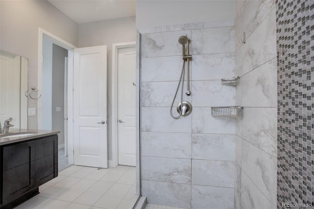 bathroom featuring vanity, a tile shower, and tile patterned flooring