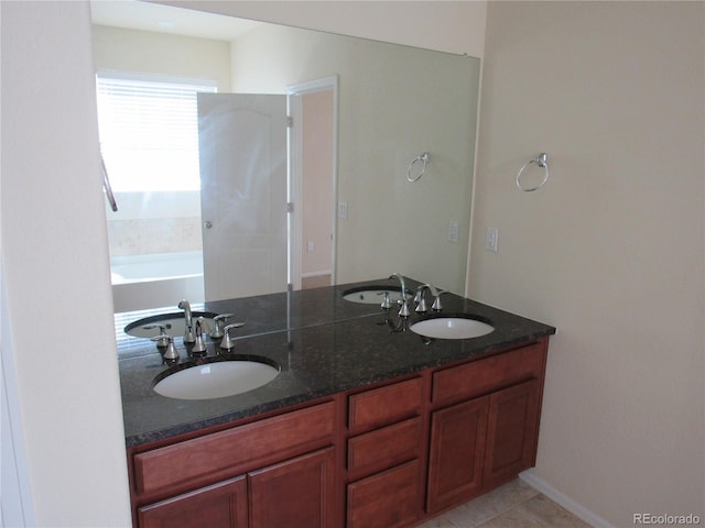 bathroom featuring double vanity, a garden tub, and a sink