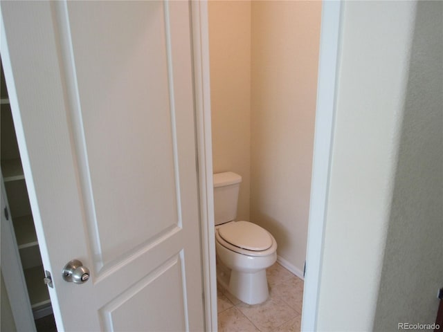 bathroom featuring tile patterned flooring, toilet, and baseboards