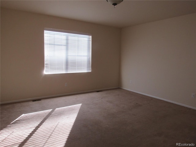 unfurnished room with light carpet and baseboards