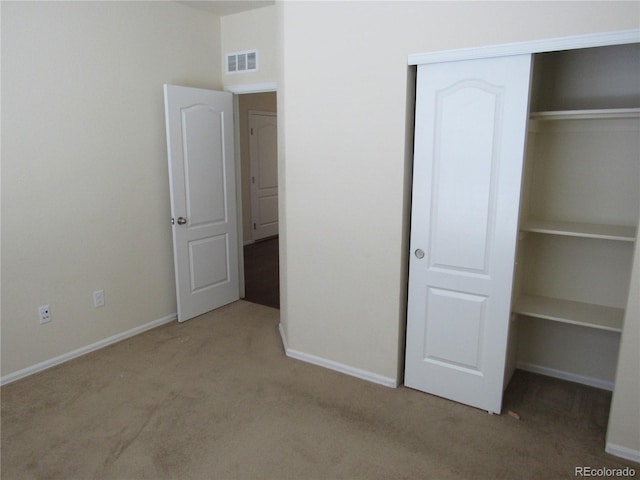 unfurnished bedroom featuring light carpet, baseboards, visible vents, and a closet