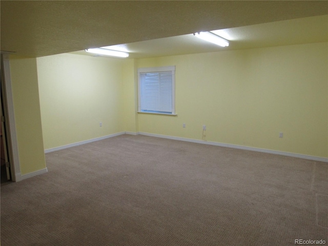 finished basement featuring light carpet and baseboards