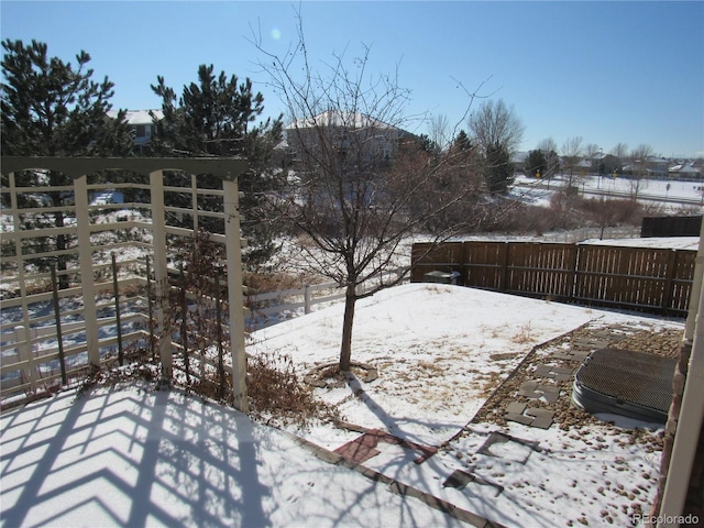 snowy yard featuring a fenced backyard