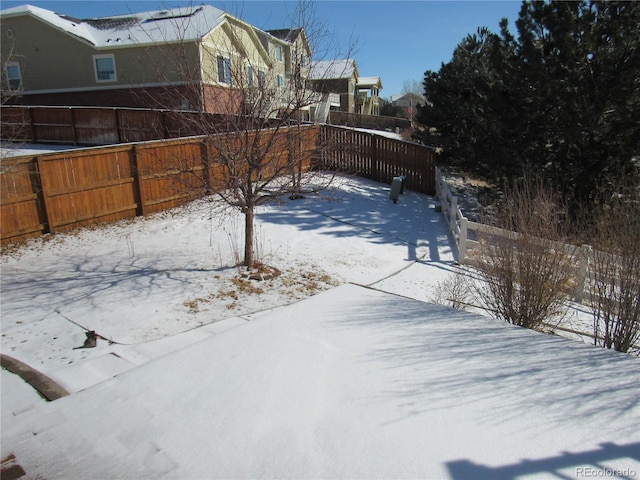 snowy yard featuring fence