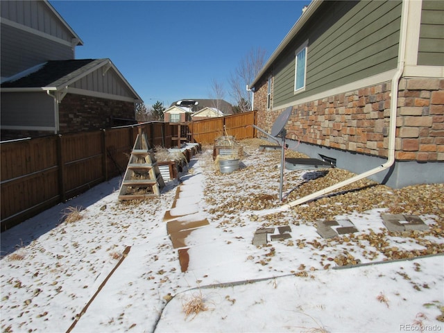 yard covered in snow featuring a fenced backyard