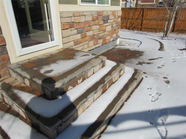 exterior details featuring stone siding and fence