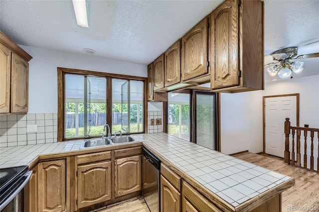 16293 E Brown Pl, Aurora, CO 80013 - kitchen featuring a sink, tile countertops, a peninsula, appliances with stainless steel finishes, and backsplash