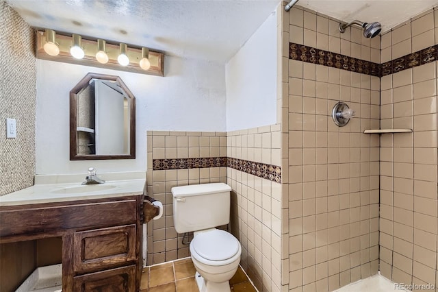16293 E Brown Pl, Aurora, CO 80013 - full bathroom with a tile shower, toilet, vanity, tile patterned floors, and tile walls