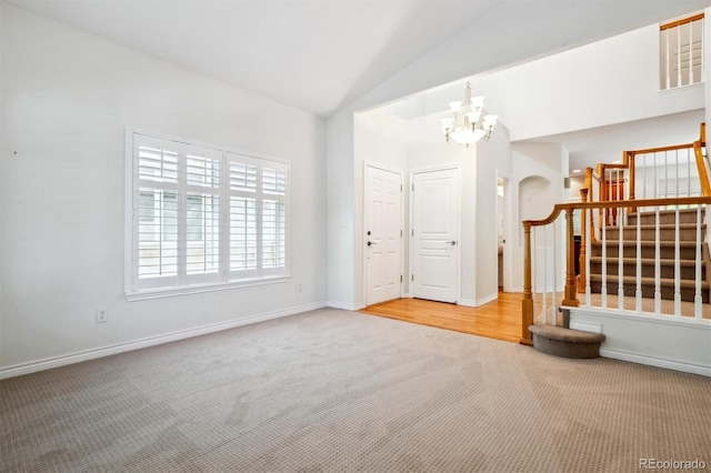11969 E Lake Cir, Greenwood Village, CO 80111 - carpeted spare room with stairs, a chandelier, vaulted ceiling, baseboards, and arched walkways