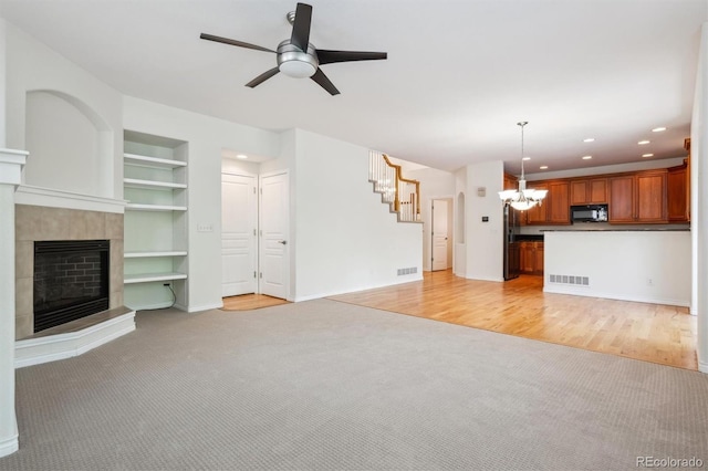 11969 E Lake Cir, Greenwood Village, CO 80111 - unfurnished living room featuring a chandelier, light carpet, a tiled fireplace, a ceiling fan, and recessed lighting