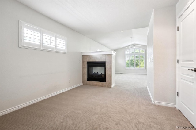 11969 E Lake Cir, Greenwood Village, CO 80111 - unfurnished living room featuring a tiled fireplace, carpet, vaulted ceiling, ceiling fan, and baseboards