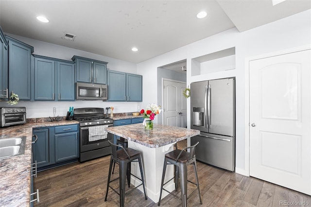 4405 Walden Ct, Denver, CO 80249 - kitchen with stainless steel appliances, a kitchen bar, dark wood-style flooring, recessed lighting, and blue cabinets