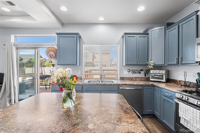 4405 Walden Ct, Denver, CO 80249 - kitchen featuring stainless steel appliances, a sink, dark countertops, recessed lighting, and blue cabinets