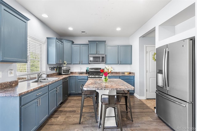 4405 Walden Ct, Denver, CO 80249 - kitchen featuring appliances with stainless steel finishes, a sink, blue cabinets, dark wood-style floors, and recessed lighting
