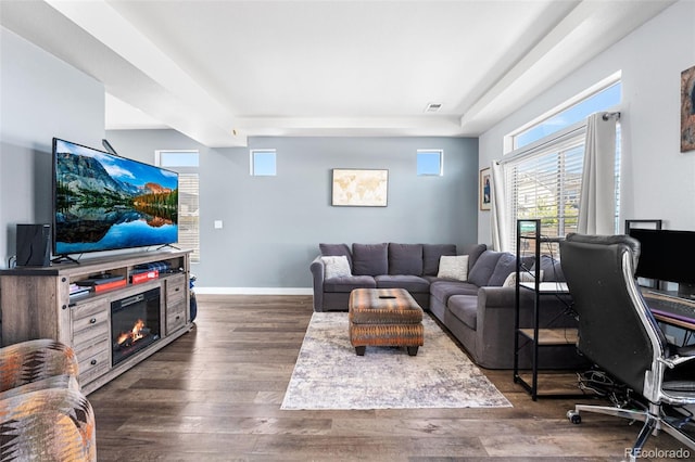 4405 Walden Ct, Denver, CO 80249 - living area featuring dark wood finished floors, baseboards, a glass covered fireplace, and a raised ceiling