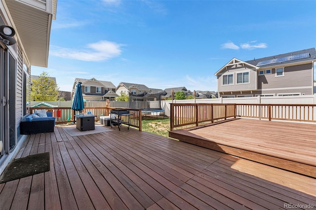 4405 Walden Ct, Denver, CO 80249 - wooden deck featuring a trampoline, a residential view, and a fenced backyard