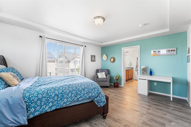 4405 Walden Ct, Denver, CO 80249 - bedroom featuring wood finished floors, a tray ceiling, and baseboards