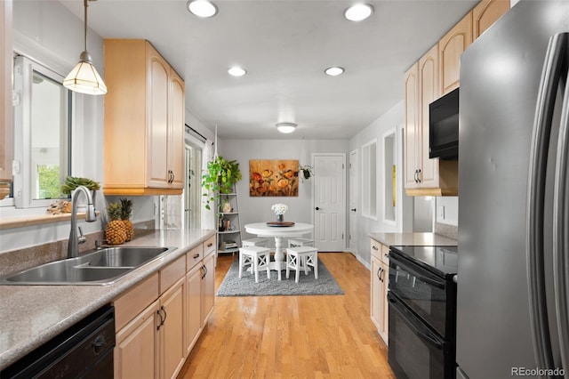kitchen with light brown cabinets, black appliances, a sink, and light wood-style flooring