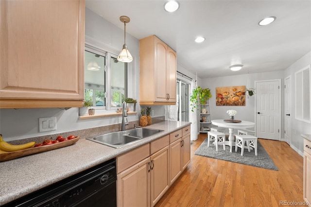 kitchen with light brown cabinetry, black dishwasher, a sink, and light wood-style flooring