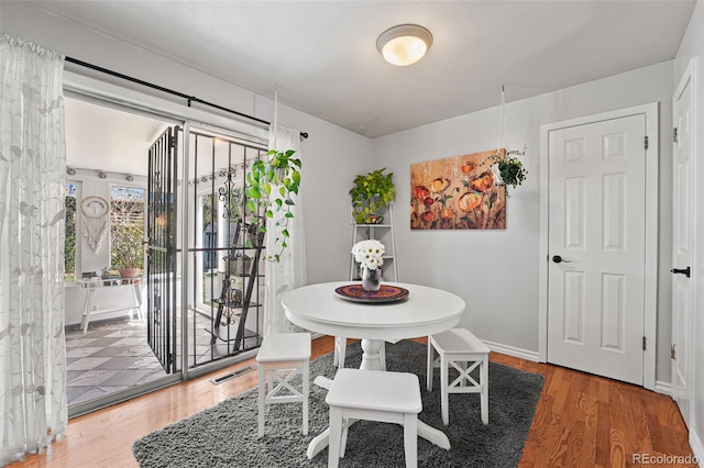 dining space featuring wood finished floors and visible vents