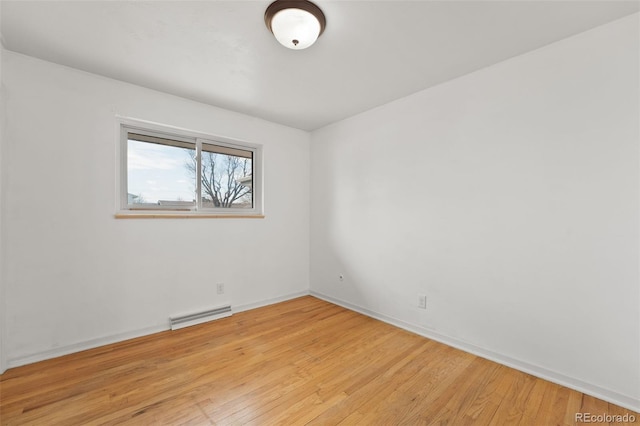 unfurnished room featuring light wood-style flooring, visible vents, and baseboards