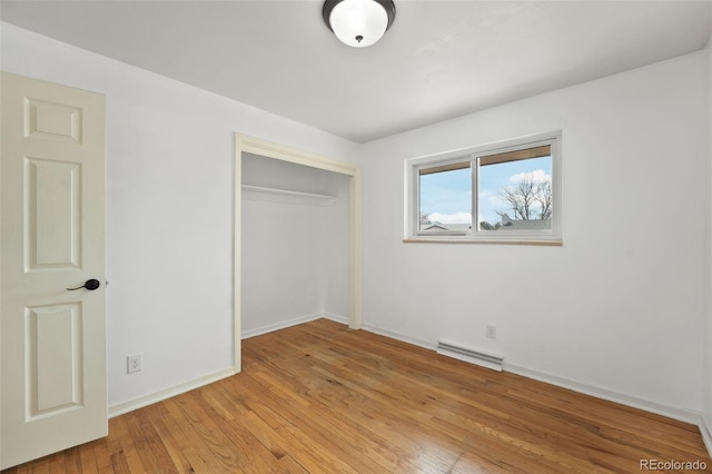 unfurnished bedroom with baseboards, light wood-style flooring, visible vents, and a closet