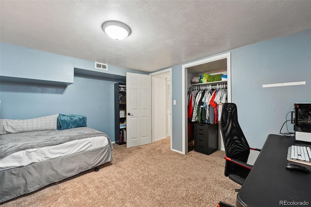 bedroom featuring a closet, visible vents, carpet flooring, and a textured ceiling