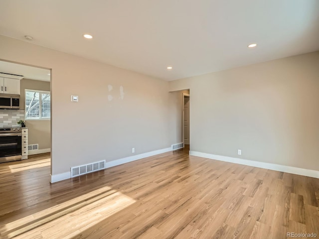 unfurnished room with light wood-type flooring