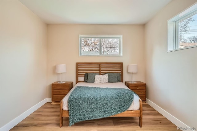 bedroom with hardwood / wood-style floors and multiple windows