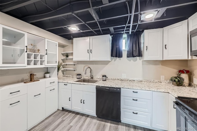 kitchen with light wood-type flooring, white cabinetry, black appliances, and sink