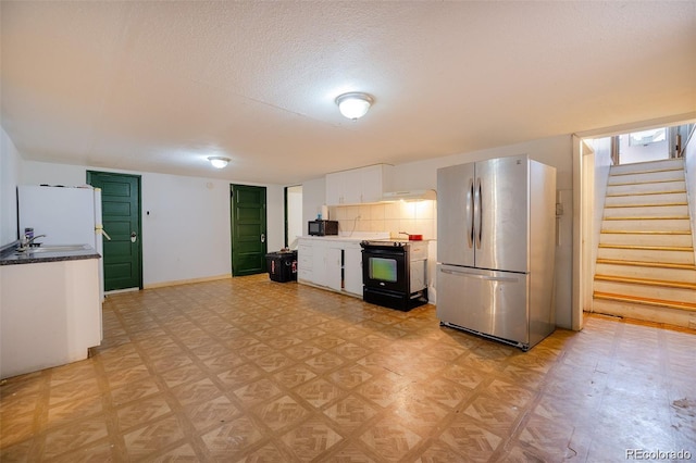 612 W Bijou Ave, Fort Morgan, CO 80701 - kitchen featuring black appliances, white cabinetry, a textured ceiling, and light floors