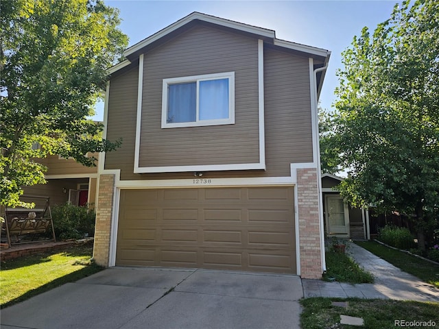 view of front of property featuring a garage, concrete driveway, and brick siding