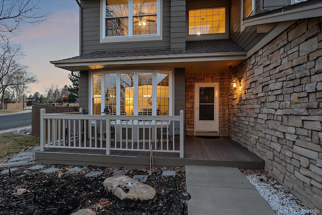 exterior entry at dusk featuring a porch