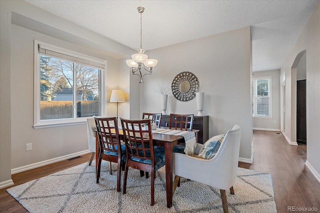 dining room with dark wood-type flooring and a textured ceiling