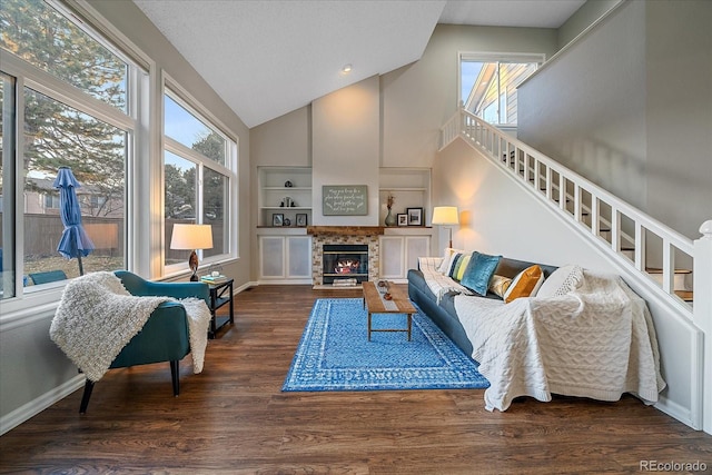 living room with high vaulted ceiling, dark hardwood / wood-style flooring, and built in shelves