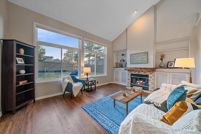 living room with built in shelves, dark hardwood / wood-style flooring, and high vaulted ceiling