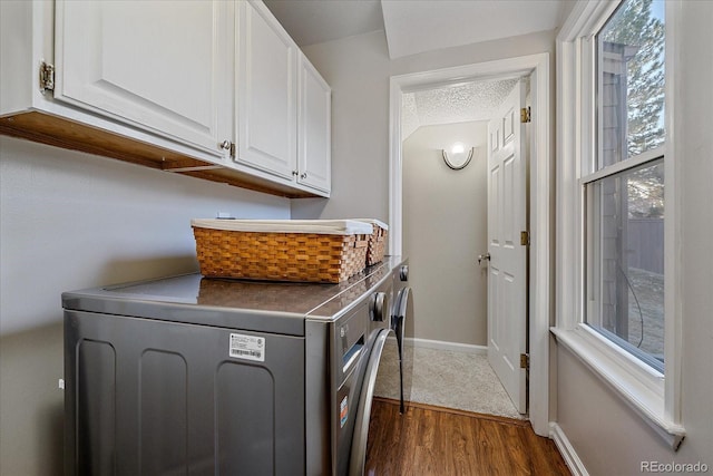 washroom featuring cabinets, dark hardwood / wood-style floors, washer and dryer, and a textured ceiling