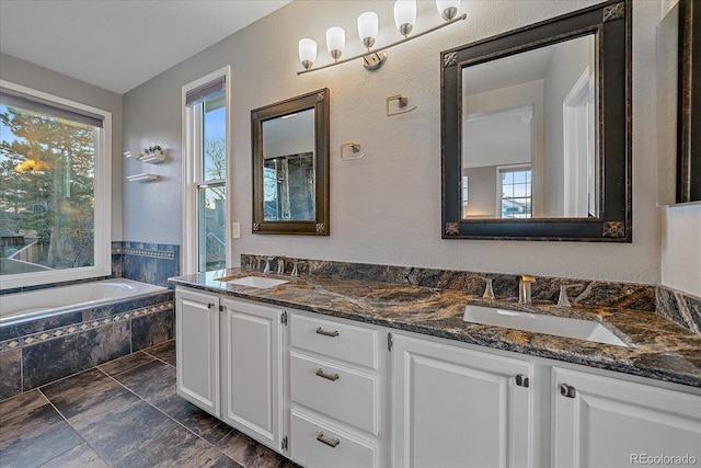 bathroom featuring vanity and a relaxing tiled tub