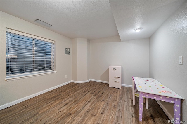 game room featuring wood-type flooring and a textured ceiling