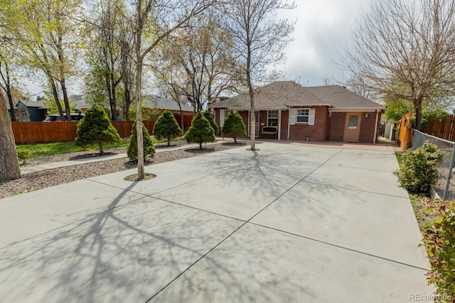 3021 Grape St, Denver, CO 80207 - ranch-style home featuring concrete driveway, brick siding, and fence