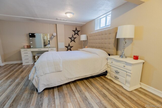 3021 Grape St, Denver, CO 80207 - bedroom featuring light wood-style flooring, baseboards, and a textured ceiling