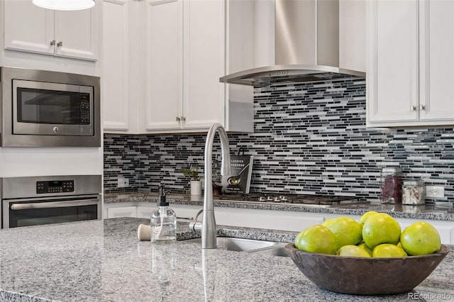 5068 Yosemite Ct, Denver, CO 80238 - kitchen featuring stainless steel appliances, island range hood, white cabinetry, and tasteful backsplash