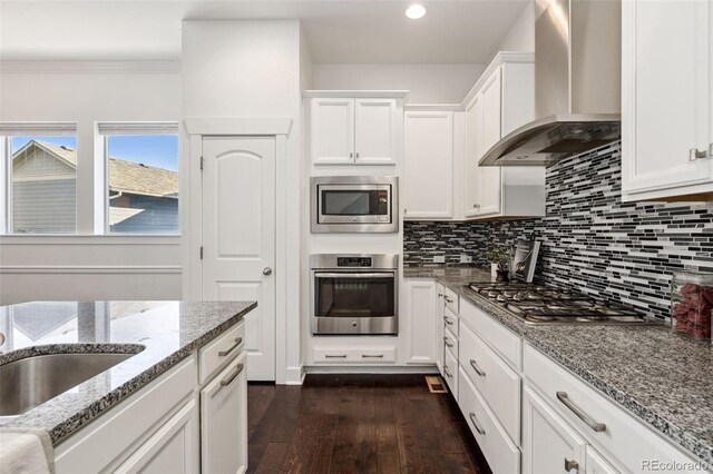 5068 Yosemite Ct, Denver, CO 80238 - kitchen featuring wall chimney exhaust hood, stainless steel appliances, dark wood-type flooring, decorative backsplash, and white cabinets
